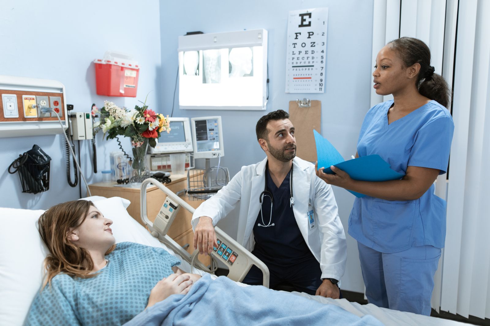 Doctor and nurse discussing care at a patient's bedside