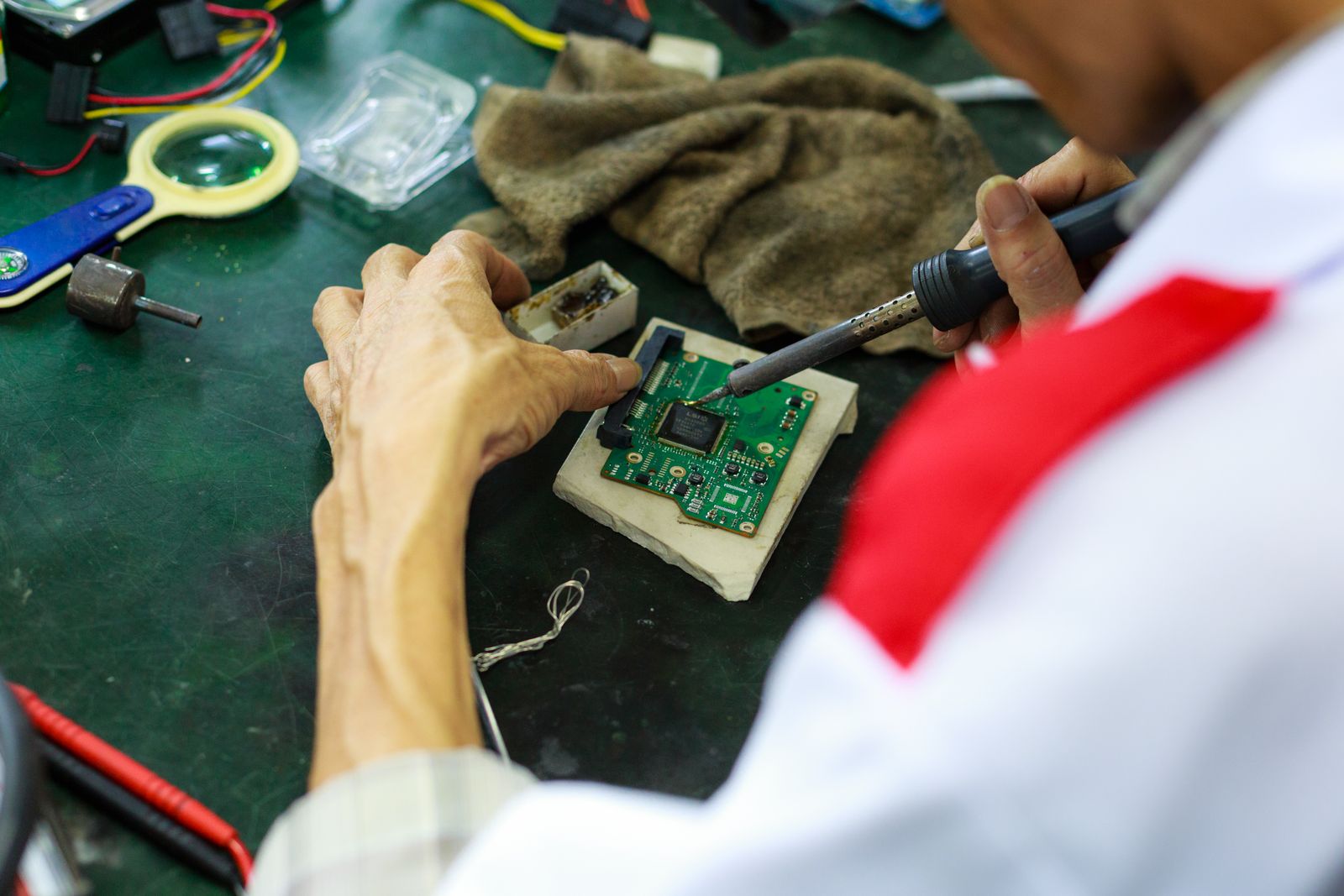Technician soldering components on a circuit board